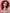 A woman with voluminous curly brown hair wearing a light pink jacket, set against a solid pink background with the Eazicolor Professional logo at the bottom.